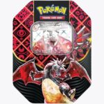 A Pokémon trading card tin called the "Pokemon Paldean Fates Charizard Tin," featuring a colorful design with red and black patterns, showcases a Charizard VMAX card with a dragon illustration prominently in the center.